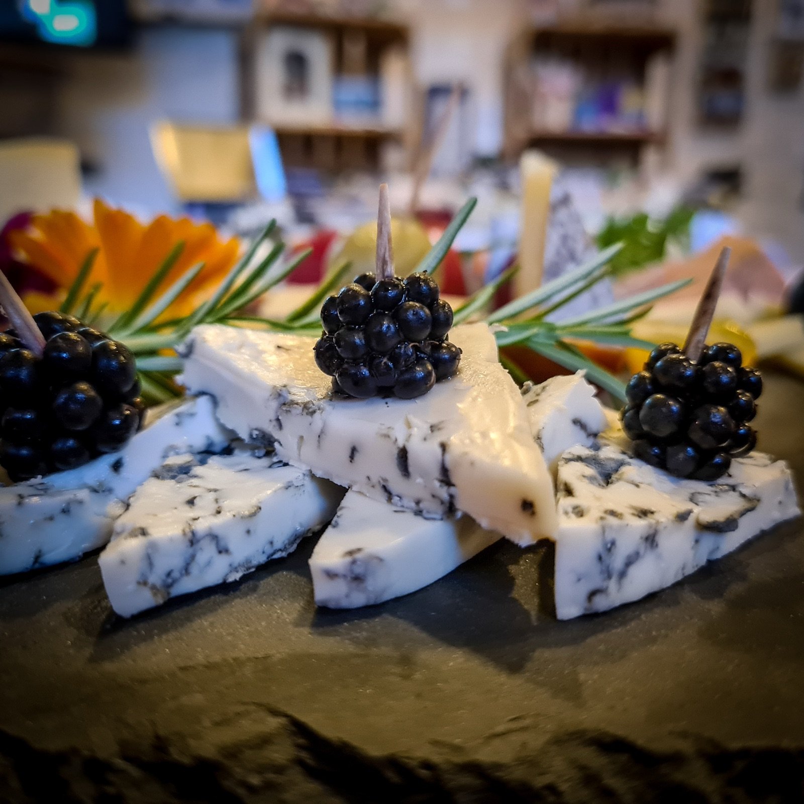 Blauschimmelkäse mit frischen Brombeeren und Rosmarin auf Schiefer
