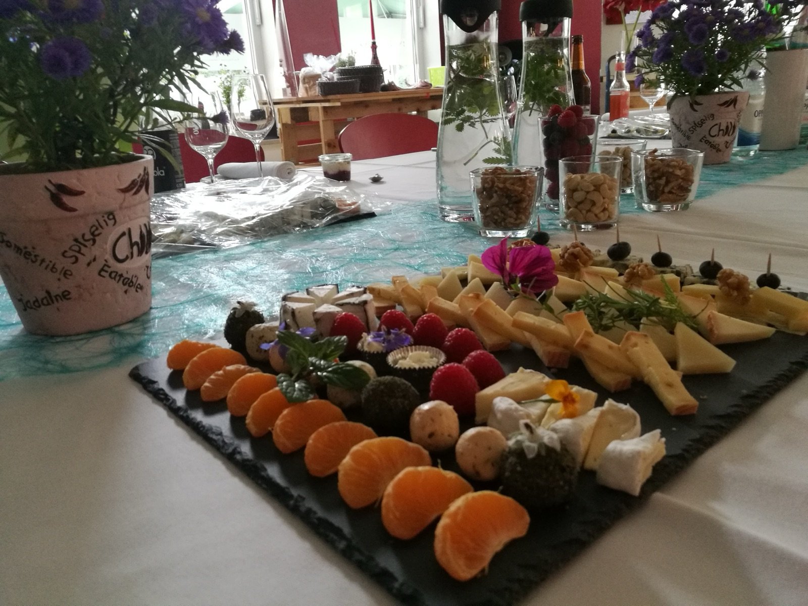 Große Käse-Buffetplatte mit Mandarinen, Beeren und Nüssen